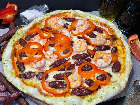 Pizza "With tiger shrimp and hunting sausages"
